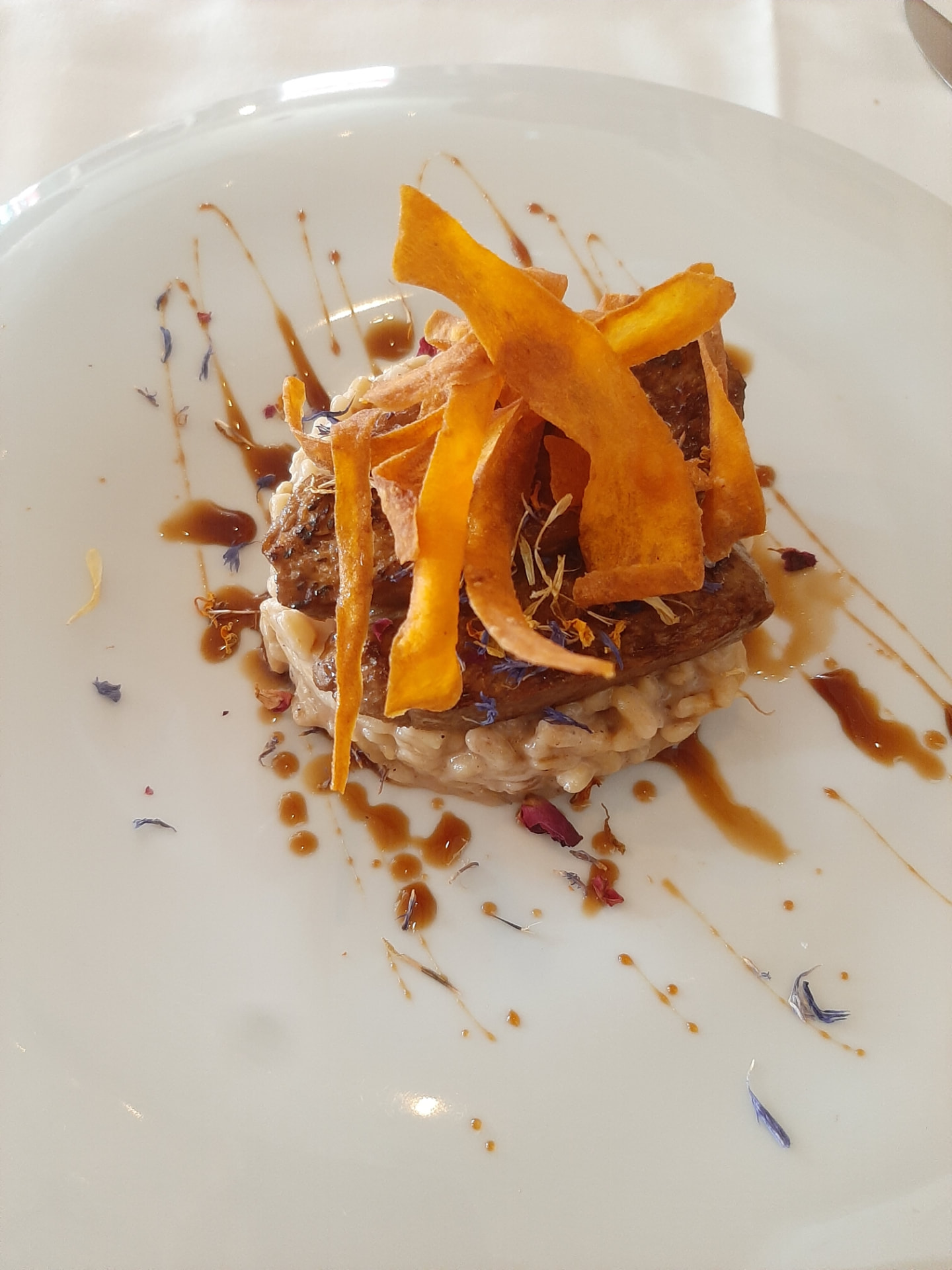 Plated plant-based dish with crispy vegetable ribbons and sauce — Plant on Fire private chef